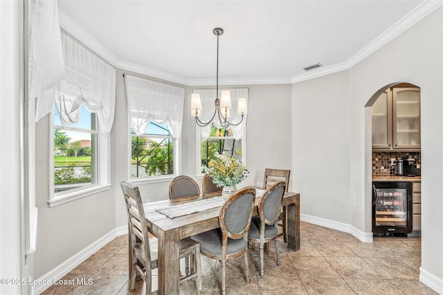 dining area with crown molding, visible vents, a chandelier, beverage cooler, and baseboards