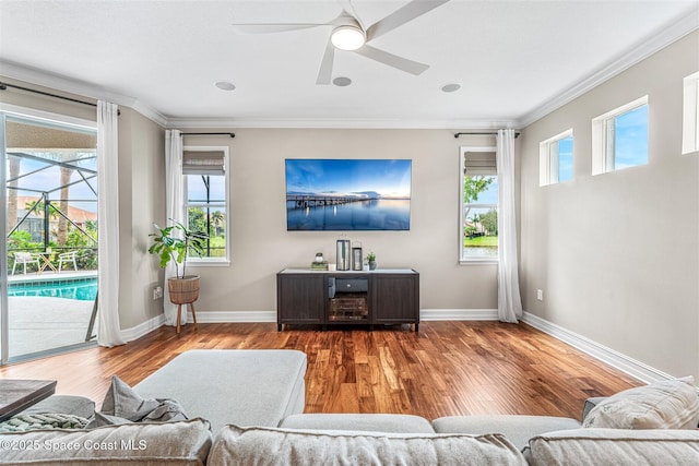 living room featuring crown molding, wood finished floors, and ceiling fan