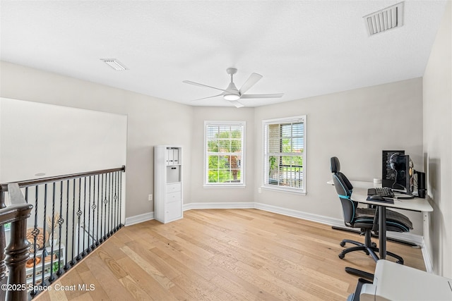 office space with visible vents, a ceiling fan, and wood finished floors