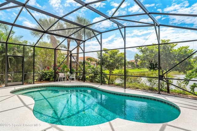outdoor pool featuring a patio and glass enclosure