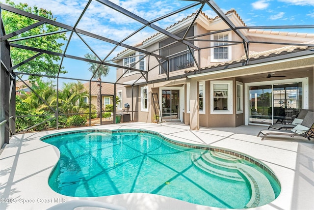 pool featuring a lanai, a patio area, and a ceiling fan