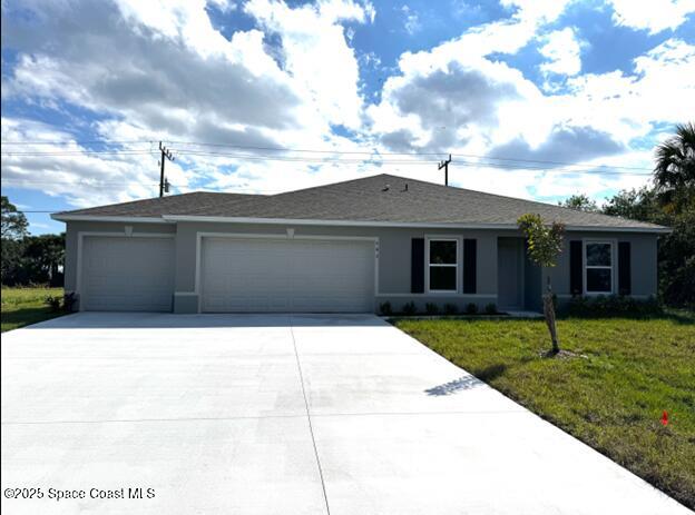 ranch-style house featuring a front lawn, an attached garage, driveway, and stucco siding