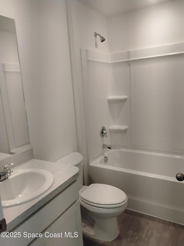 bathroom with toilet,  shower combination, wood finished floors, and vanity