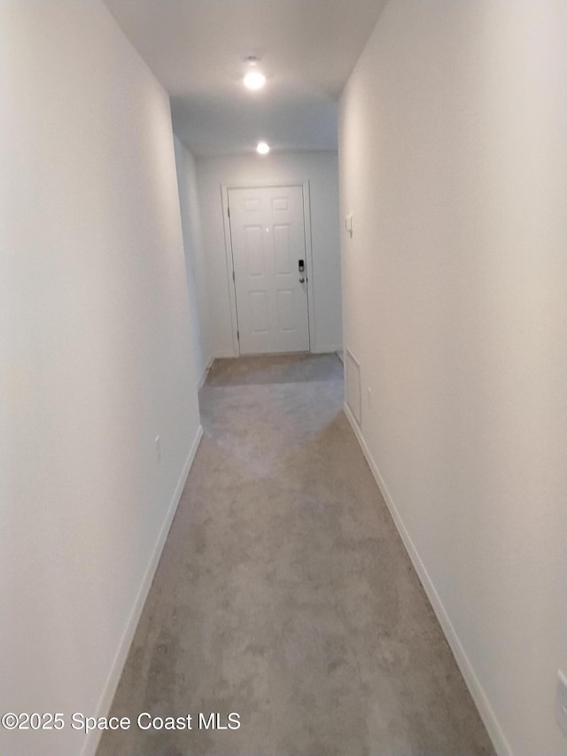 hallway with light colored carpet and baseboards