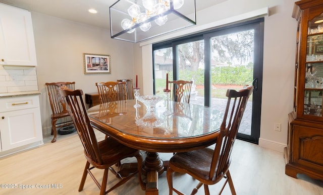 dining room with baseboards, recessed lighting, light wood-type flooring, and a notable chandelier