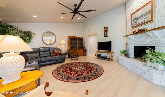 living area with recessed lighting, a brick fireplace, vaulted ceiling, ceiling fan, and wood finished floors