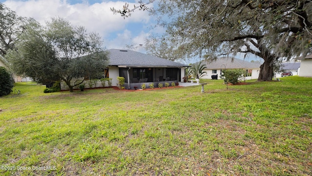 rear view of property featuring a sunroom and a lawn