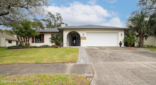 ranch-style house with a garage, driveway, stucco siding, a front lawn, and a chimney