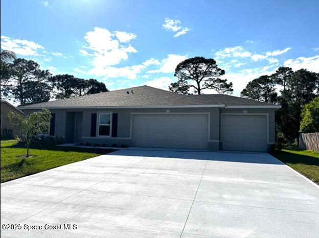 ranch-style home with stucco siding, driveway, an attached garage, and a front lawn