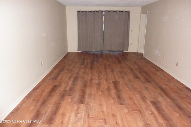 empty room featuring baseboards and wood finished floors