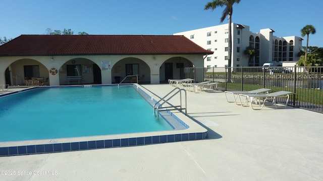 community pool featuring a patio area and fence