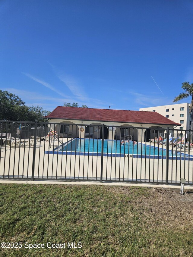 community pool with fence and a patio