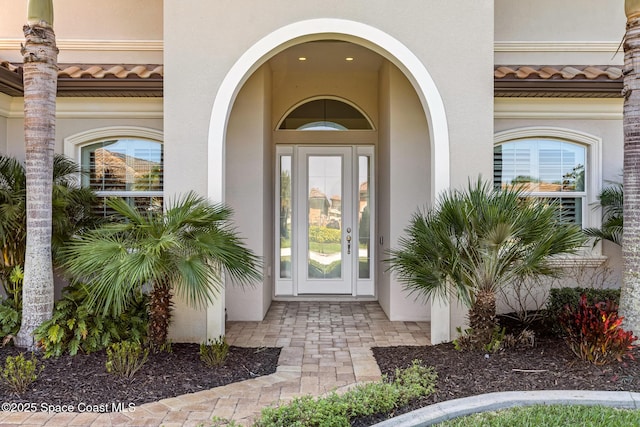 doorway to property with a tiled roof and stucco siding