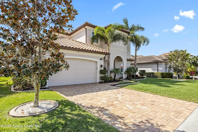 mediterranean / spanish-style house featuring a tile roof, an attached garage, decorative driveway, a front lawn, and stucco siding