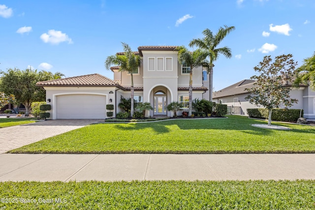 mediterranean / spanish-style home featuring a garage, a tile roof, decorative driveway, stucco siding, and a front yard