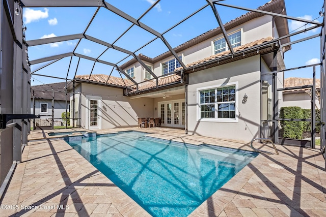 rear view of house with a ceiling fan, a tile roof, french doors, and a patio area