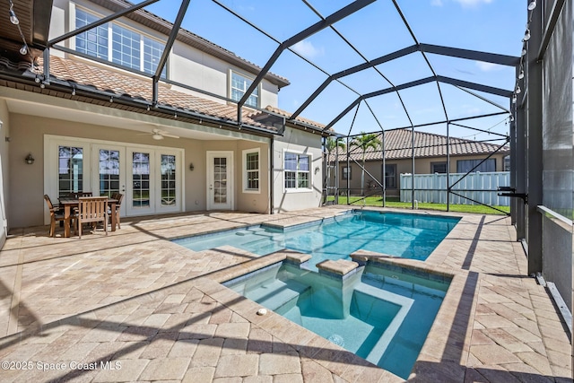 view of swimming pool featuring ceiling fan, glass enclosure, a pool with connected hot tub, french doors, and a patio area