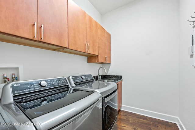 laundry room with washing machine and dryer, a sink, baseboards, cabinet space, and dark wood-style floors