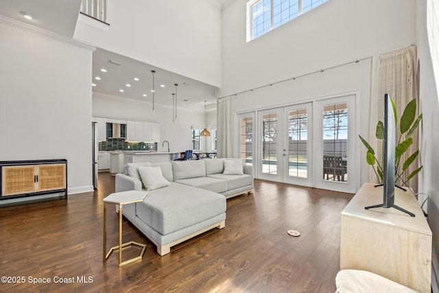 living room featuring recessed lighting, a high ceiling, french doors, dark wood finished floors, and crown molding