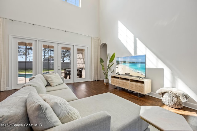 living area featuring a wealth of natural light, a high ceiling, and wood finished floors