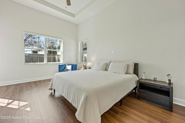 bedroom with multiple windows, ceiling fan, baseboards, and wood finished floors