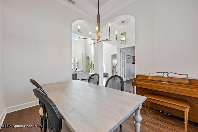 dining area featuring baseboards, ornamental molding, wood finished floors, french doors, and a chandelier