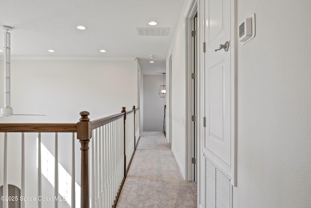 hallway featuring crown molding, recessed lighting, visible vents, and light colored carpet