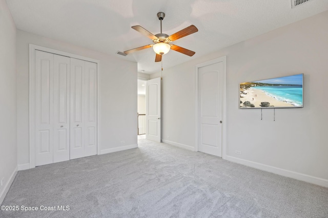 unfurnished bedroom with a closet, carpet, visible vents, and baseboards