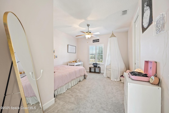 carpeted bedroom featuring a ceiling fan, visible vents, and baseboards