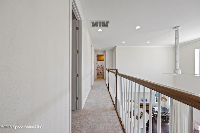 hallway with ornamental molding, light colored carpet, visible vents, and recessed lighting