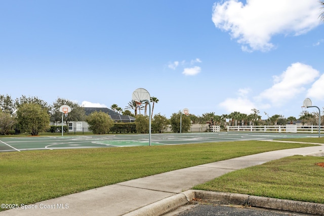 view of basketball court featuring community basketball court, fence, and a lawn