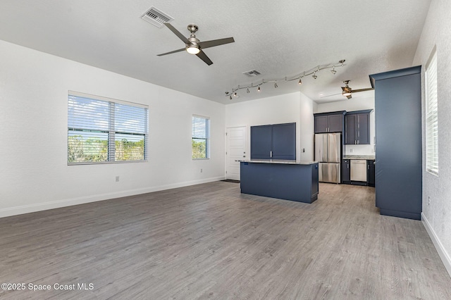 kitchen featuring stainless steel appliances, light wood finished floors, visible vents, and a center island