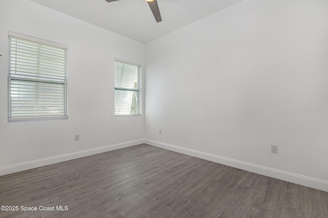 empty room with ceiling fan, baseboards, and dark wood finished floors