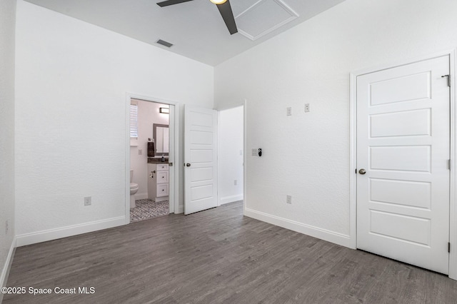 unfurnished bedroom with ensuite bath, baseboards, visible vents, and wood finished floors