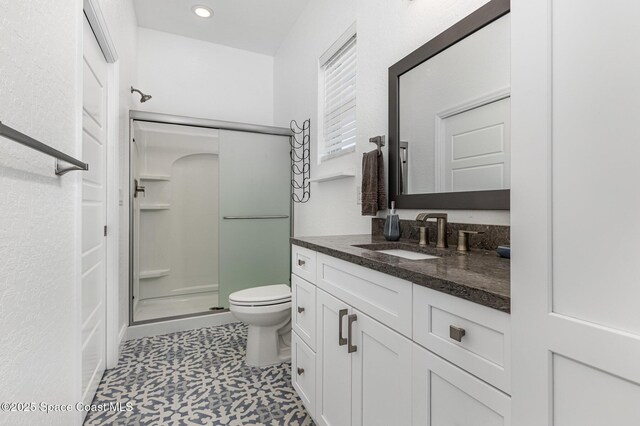 full bathroom with a stall shower, vanity, toilet, and recessed lighting