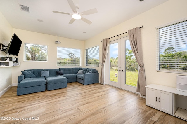 living room featuring ceiling fan, visible vents, baseboards, light wood-style floors, and french doors