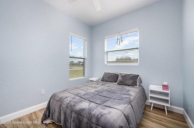 bedroom featuring a ceiling fan, baseboards, and wood finished floors