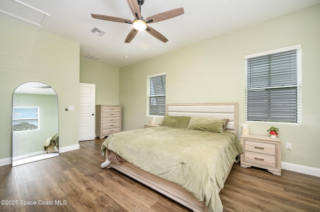 bedroom featuring baseboards, visible vents, ceiling fan, and wood finished floors