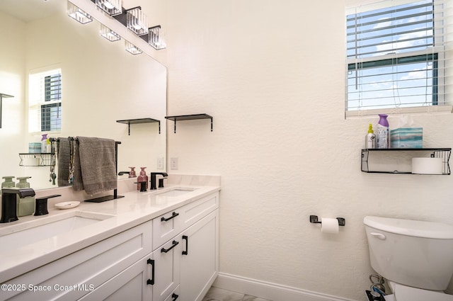 bathroom with a sink, toilet, and a healthy amount of sunlight