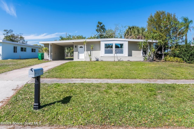 view of front of home featuring an attached carport, driveway, and a front yard