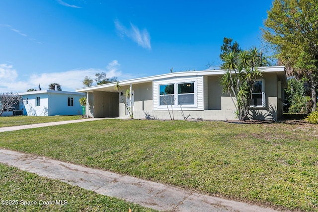 view of front of property with an attached carport, concrete driveway, and a front lawn