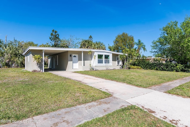 ranch-style home featuring an attached carport, driveway, and a front lawn