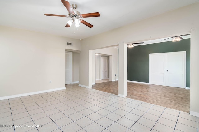 unfurnished room featuring ceiling fan, visible vents, baseboards, and light tile patterned flooring