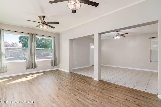 unfurnished room featuring crown molding, baseboards, light wood-type flooring, and ceiling fan