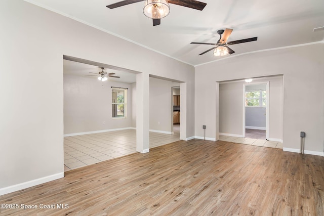 spare room featuring a ceiling fan, crown molding, wood finished floors, and baseboards