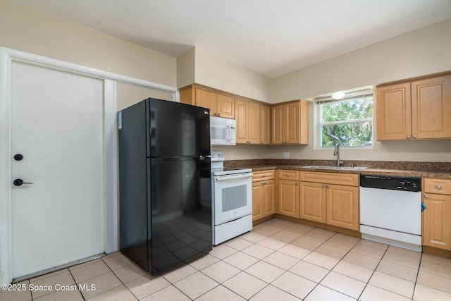 kitchen with dark countertops, light tile patterned floors, white appliances, and a sink