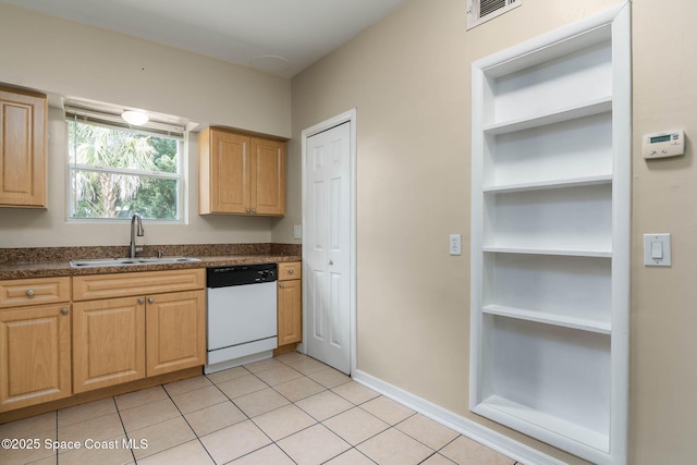 kitchen with dark countertops, visible vents, white dishwasher, light tile patterned flooring, and a sink