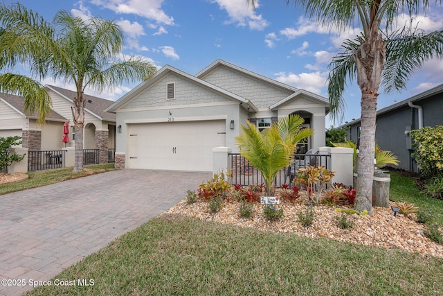 craftsman house featuring an attached garage, fence, decorative driveway, and stucco siding