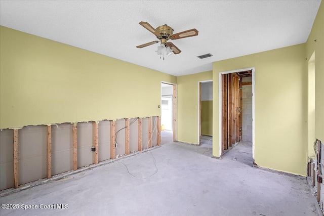 unfurnished bedroom featuring ceiling fan, a textured ceiling, unfinished concrete flooring, and visible vents