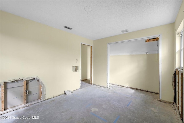 unfurnished bedroom featuring concrete flooring, visible vents, and a textured ceiling